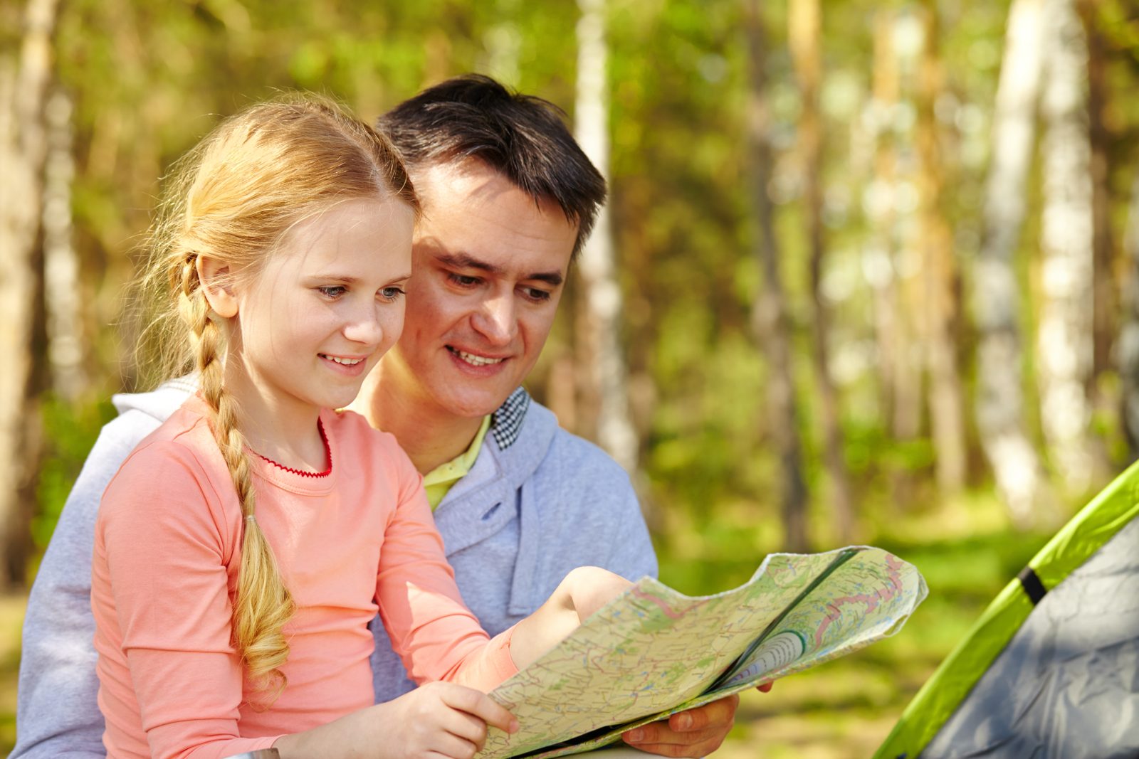 A father and daughter reading a map together outdoors